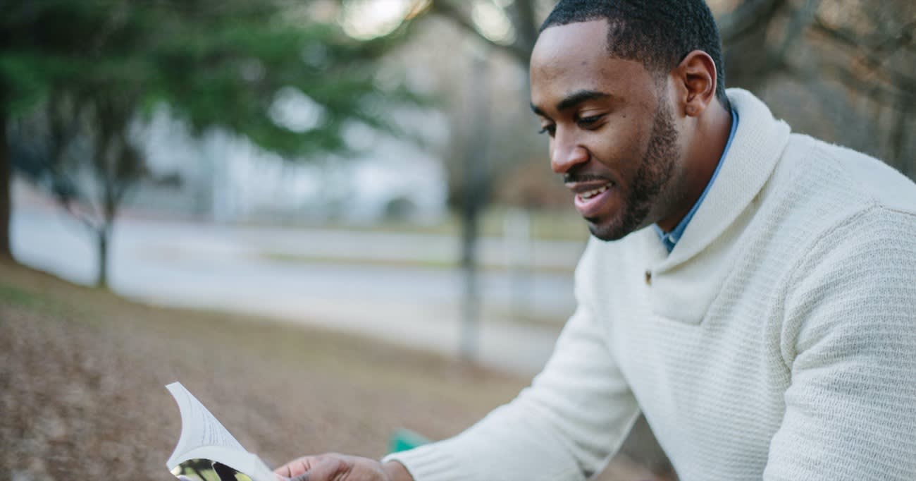 man reading a book while seated