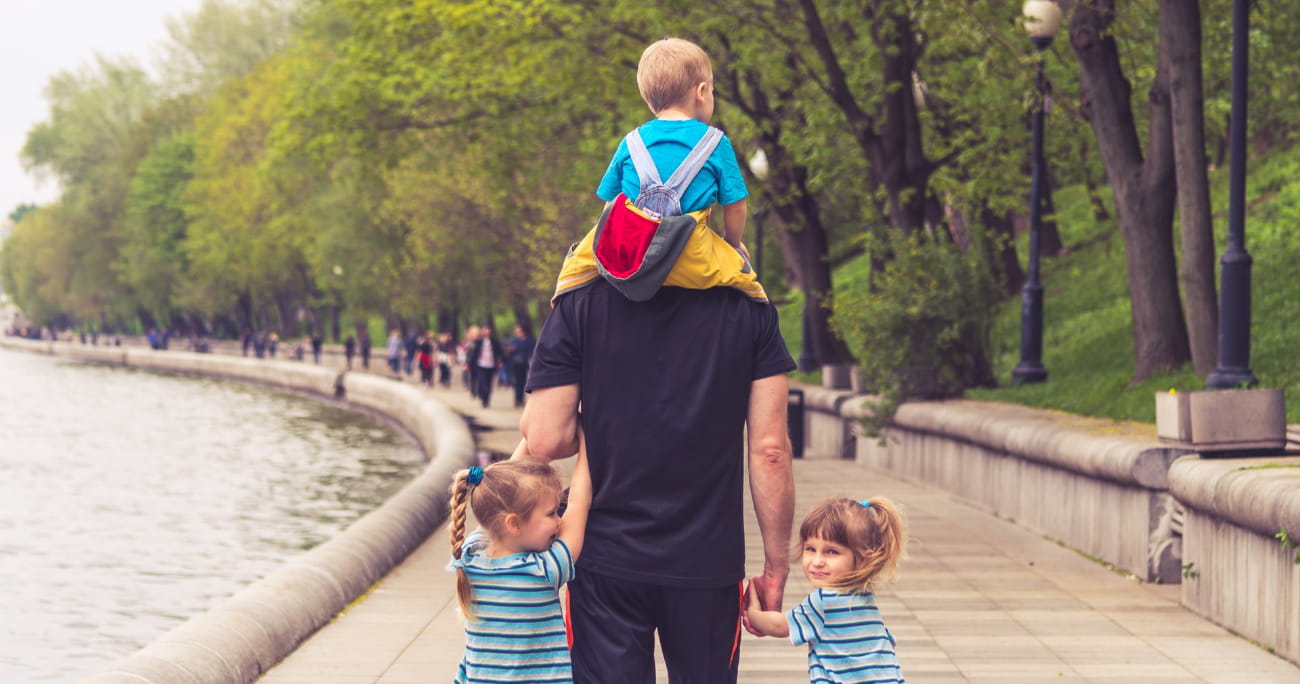 dad walking with three young children