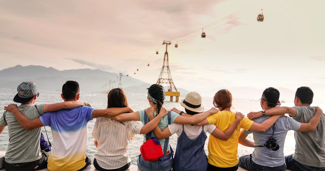 friends sitting and facing away from the camera with arms around each other