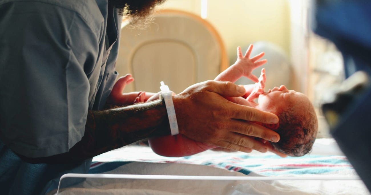 dad holding a newborn baby in the hospital