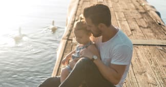 dad sitting with daughter on a dock
