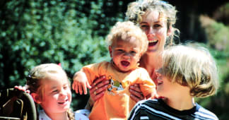 Mom with young children outside smiling and laughing