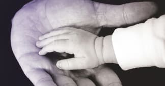 closeup of man holding child's hand