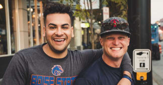 two dads smiling with arms around each others backs