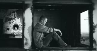 black and white photo of man with head in hands