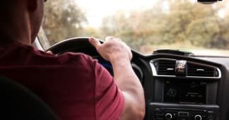 man driving in a car; view from back seat