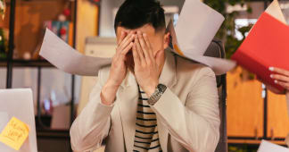 over-shoulder of a man writing in a journal