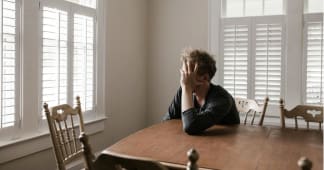 Photo of Man Leaning on Wooden Table