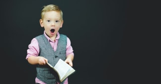 child holding a Bible with mouth open