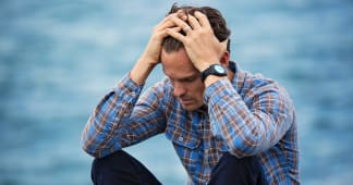Man sitting and holding his head in his hands