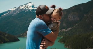 father hugging daughter in mountain landscape