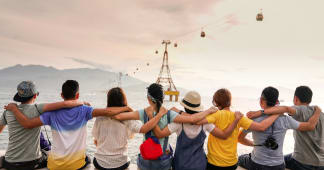 friends sitting and facing away from the camera with arms around each other