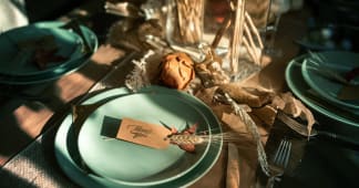 thanksgiving table place setting with "thank you" spelled out on a card