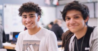 Two teenage boys smiling and looking at the camera