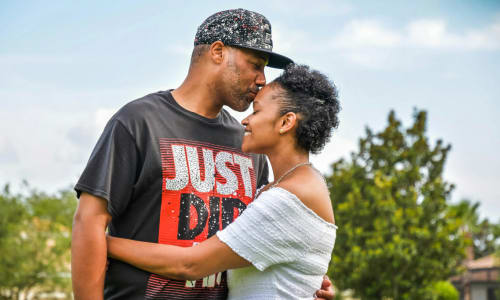 man in black crew neck t-shirt kissing woman in white dress