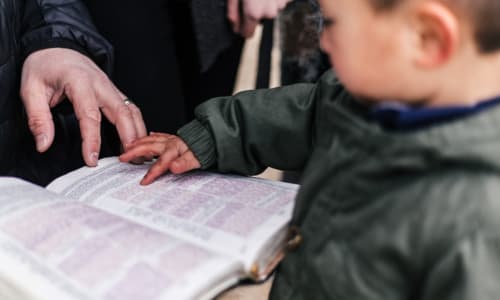 dad and son looking at an open Bible