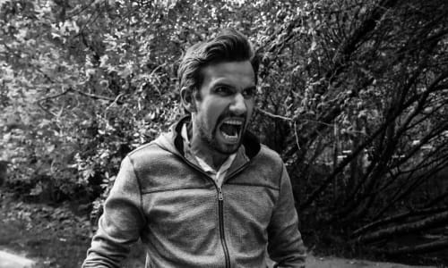 Man standing and yelling in anger
