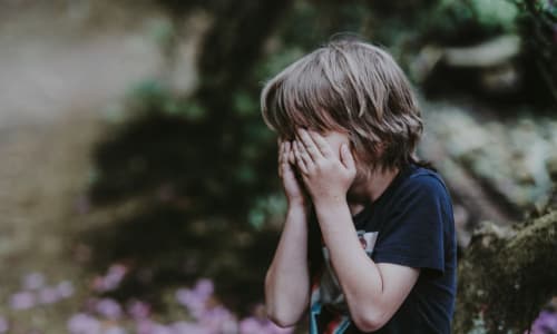 child crying with head in hands