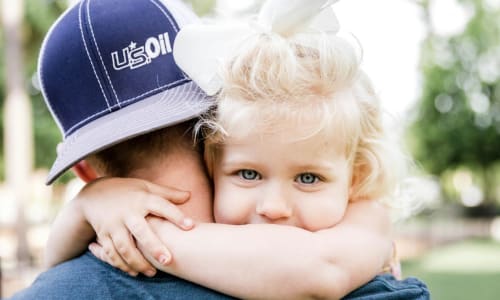 Young girl looking over the shoulder of her father