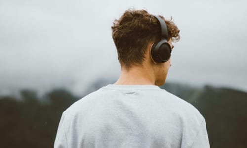 man with headphones looking at mountains | Ciocan Ciprian, via Unsplash