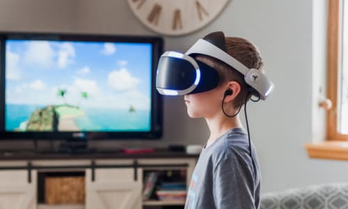 child with VR headset on in front of a TV