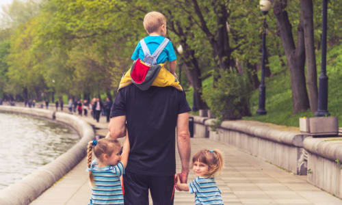 dad walking with three young children