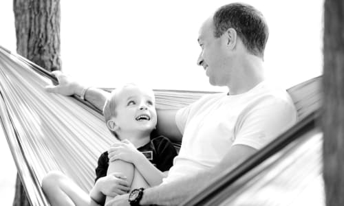 Dad and son talking and sitting in a hammock