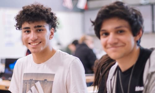 Two teenage boys smiling and looking at the camera