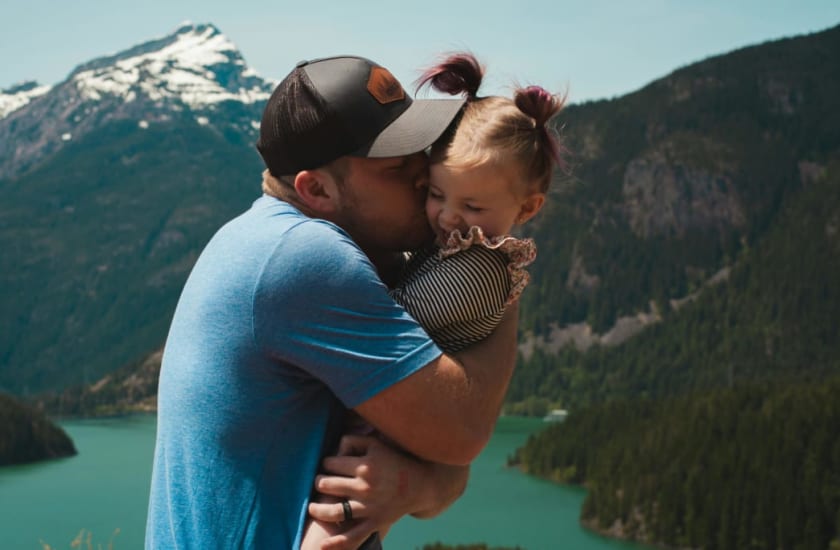 father hugging daughter in mountain landscape