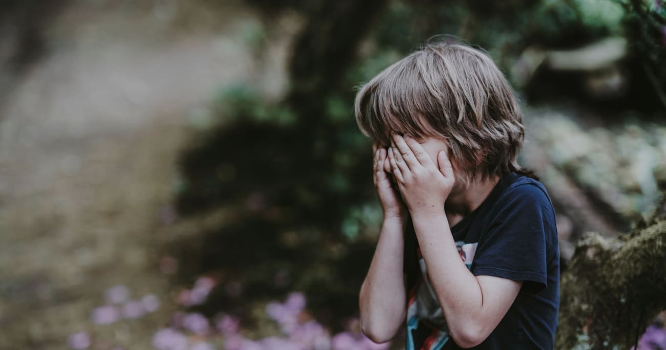 child crying with head in hands