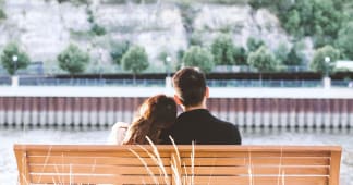 Couple sitting on a bench looking at a fountain