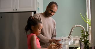 father and daughter washing dishes