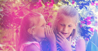 two girls whispering to each other