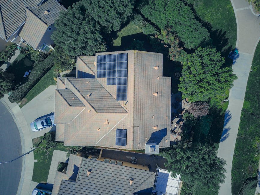 Una casa moderna con paneles solares en el techo y un jardín verde en el patio trasero