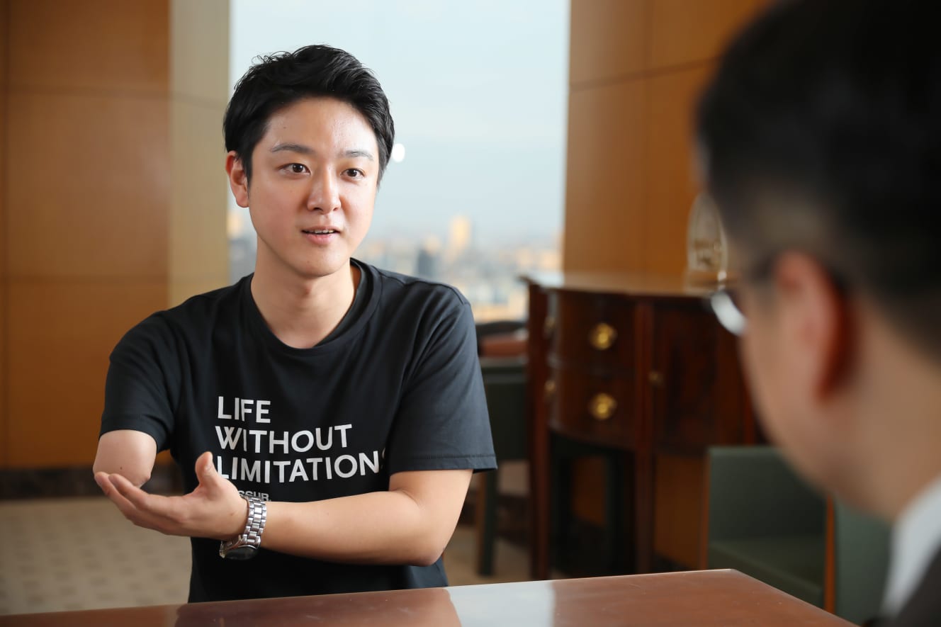 乙武洋匡氏に質問をする山田千紘さん。対談場所にはいつも通り義手・義足を装着して電車移動。「ぱっと見、ハンディキャップが分からないので、駅や電車内で人がぶつかって来るからキケン」と、屈託なく微笑む 撮影:村田克己