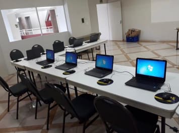 Sala de aula montada para escritório com estrutura para 8 notebooks.