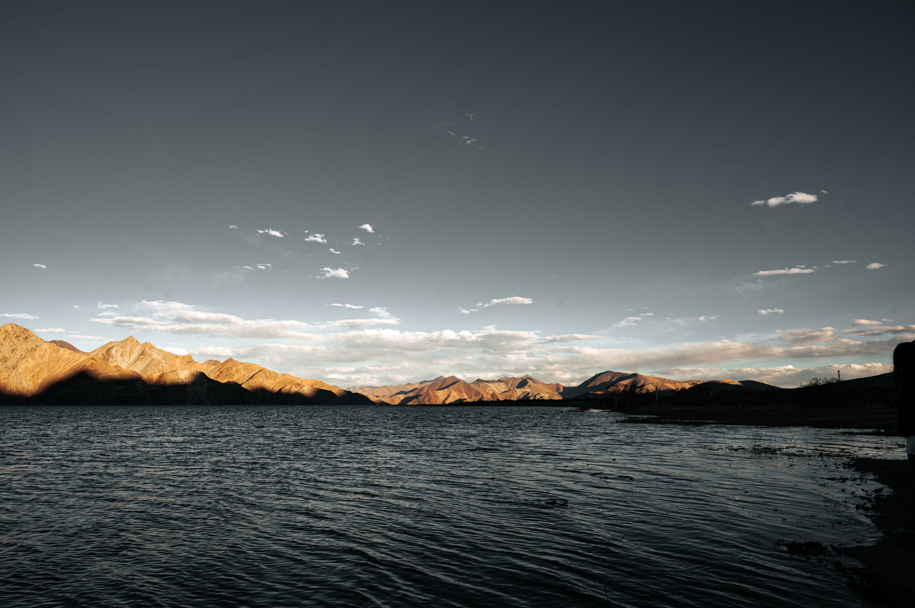 Late sun on a wide high-altitude lake with golden hills