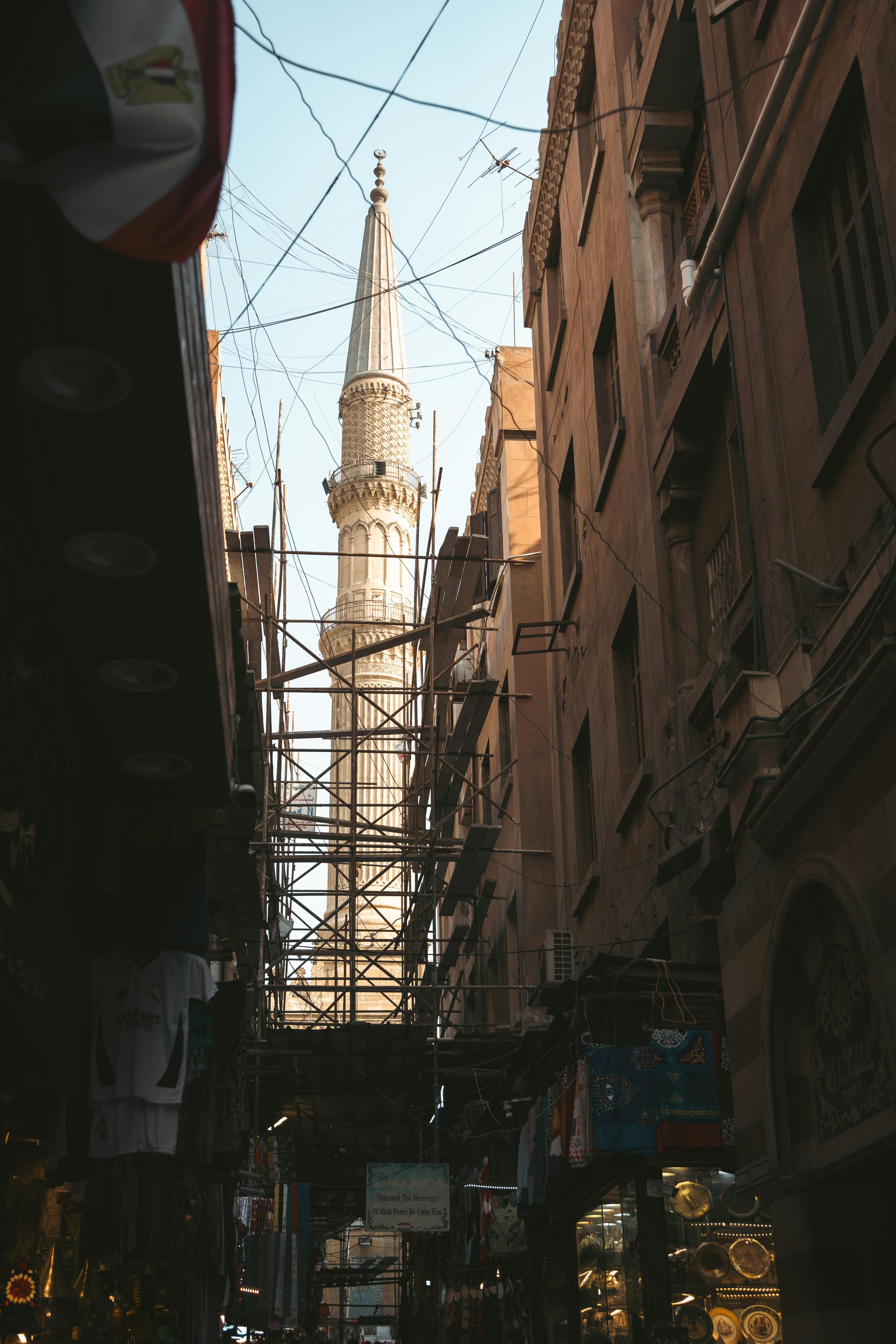 A stone minaret rising above a narrow street in old Cairo