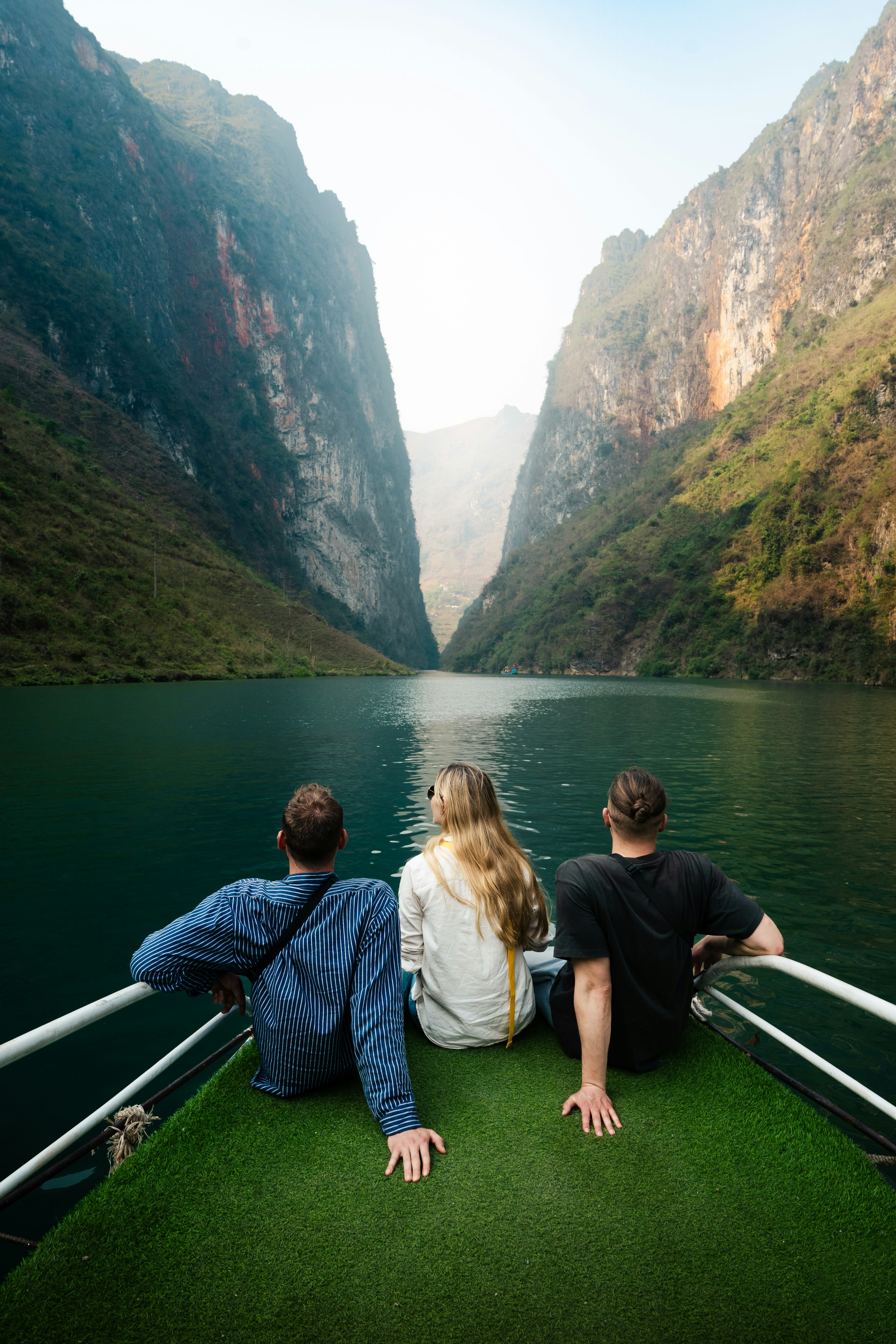 People on the bow of a small boat in a steep river gorge