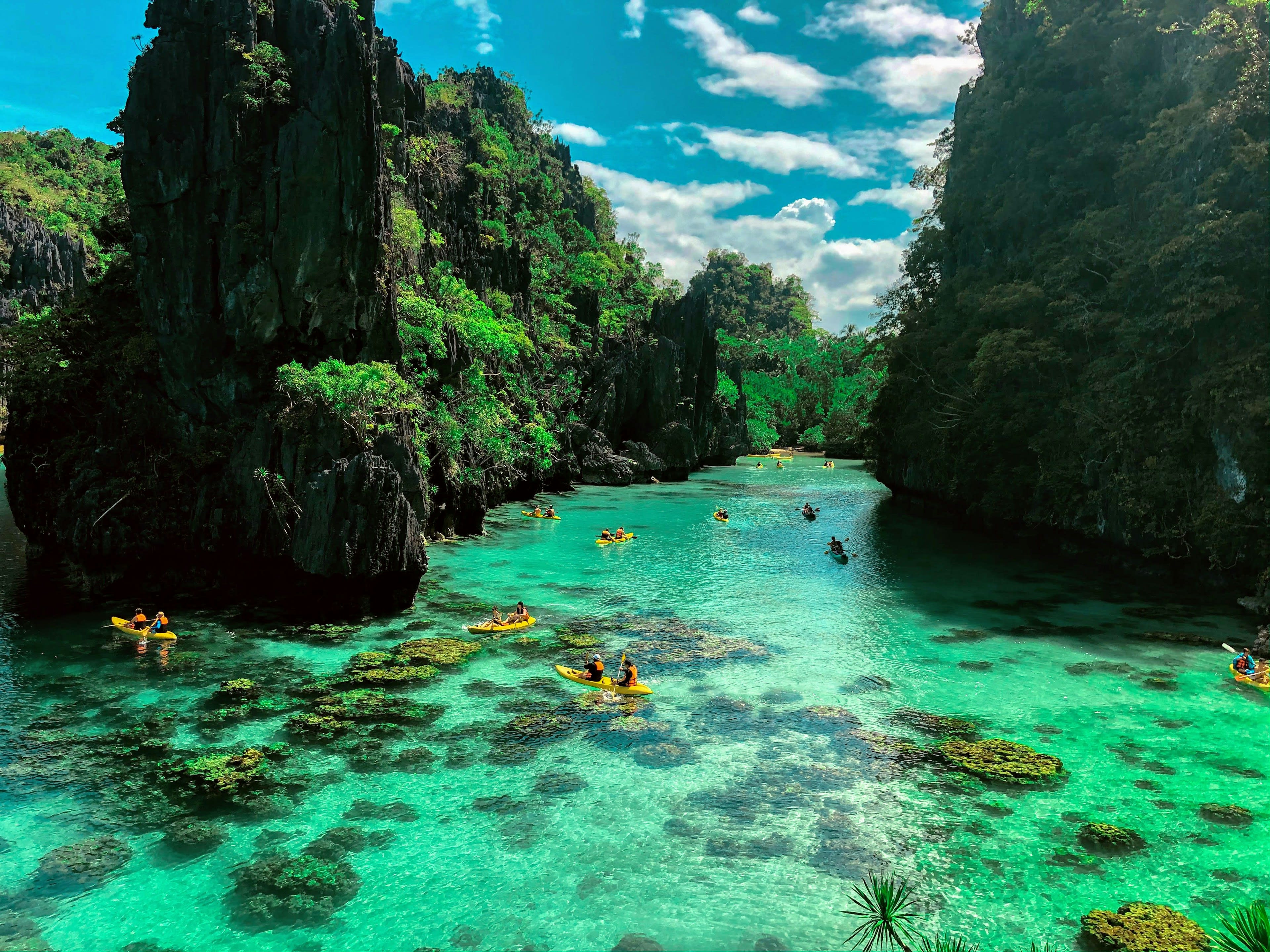 Kayakers on turquoise water enclosed by limestone cliffs
