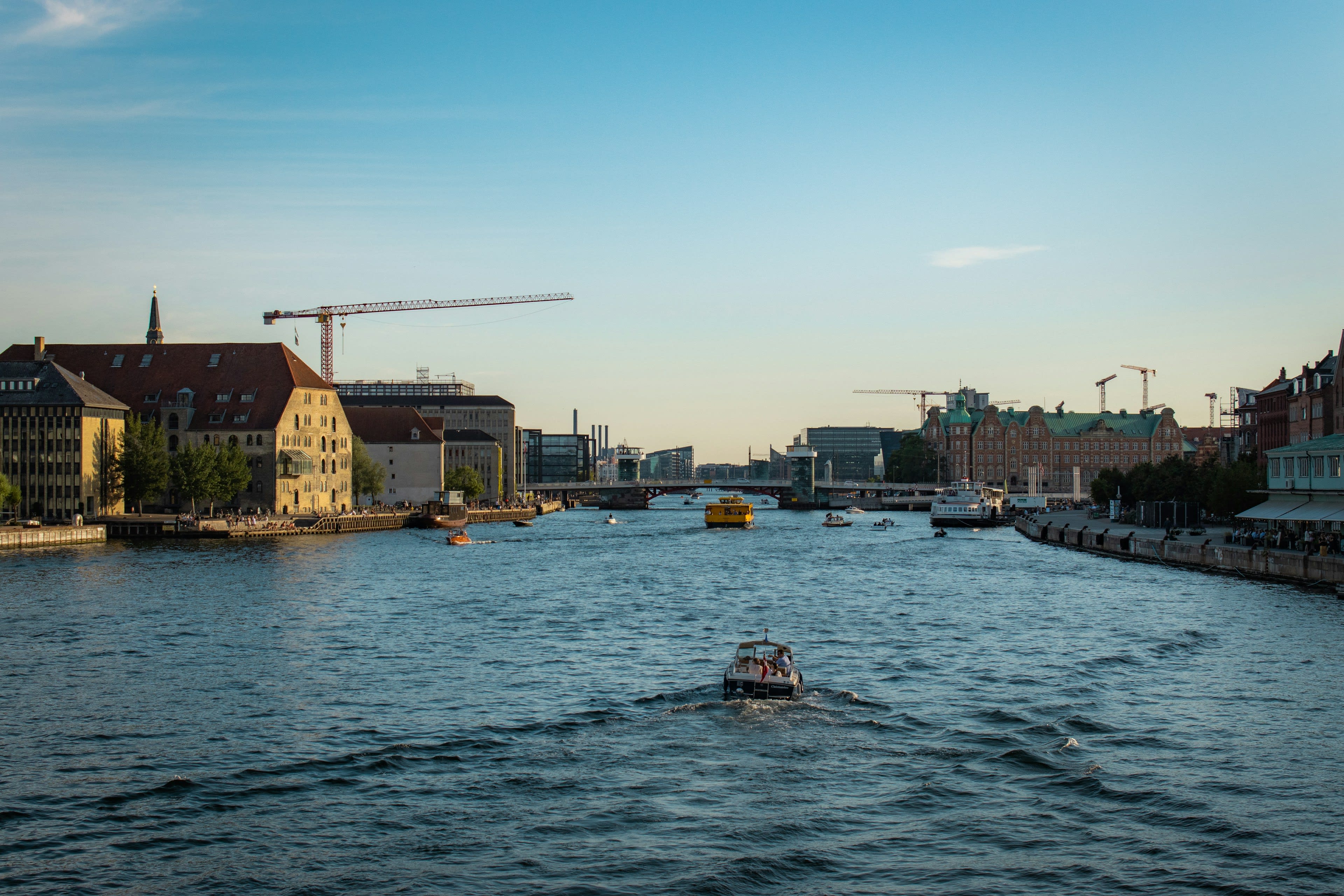 A boat moving up the Copenhagen harbour channel in evening light