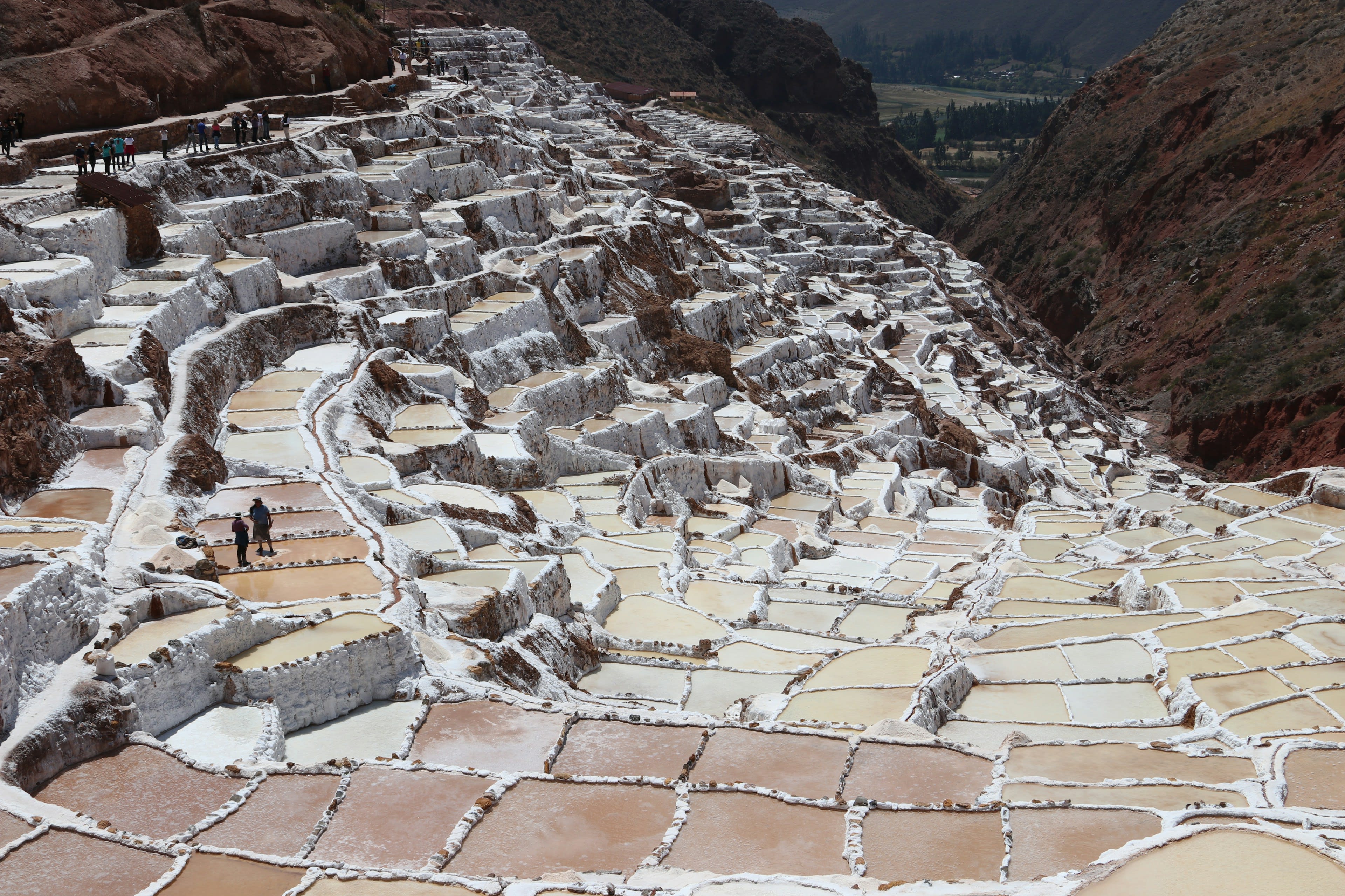 Terraced white salt evaporation pans stepping down a mountainside