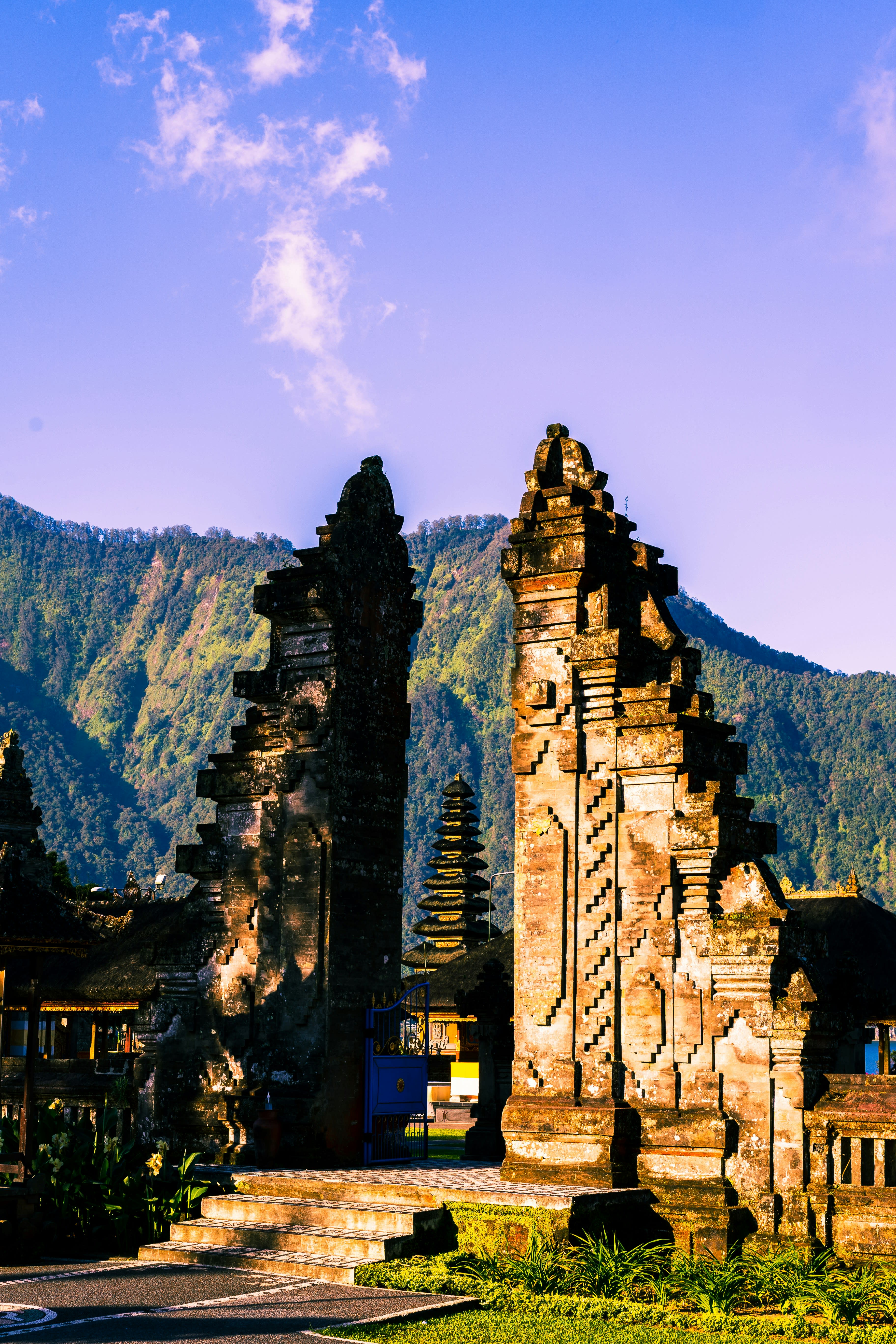 A split temple gate framing a volcano in golden light