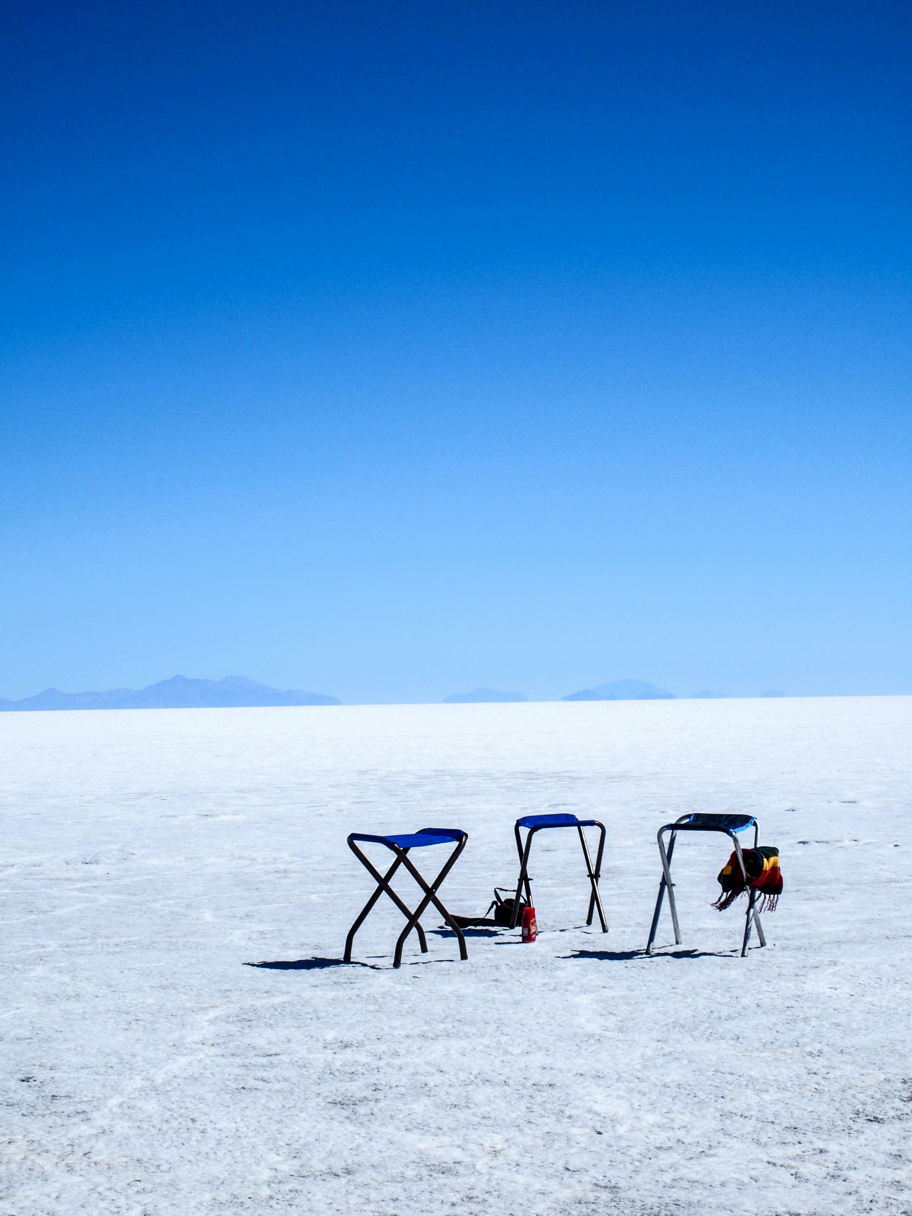 Folding camp chairs and a table set up on a white salt flat