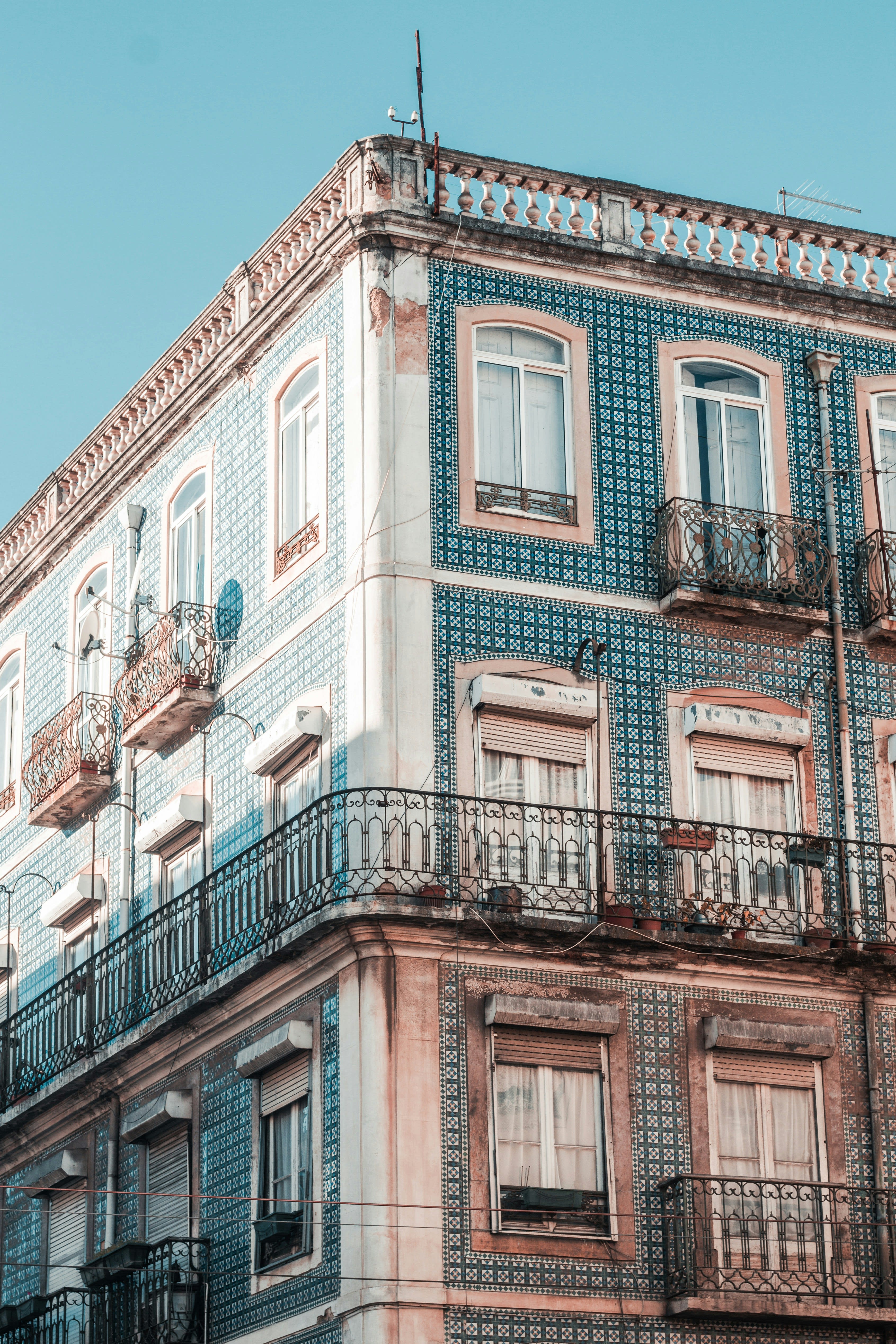 A tall building faced entirely in blue and white glazed tiles with wrought iron balconies