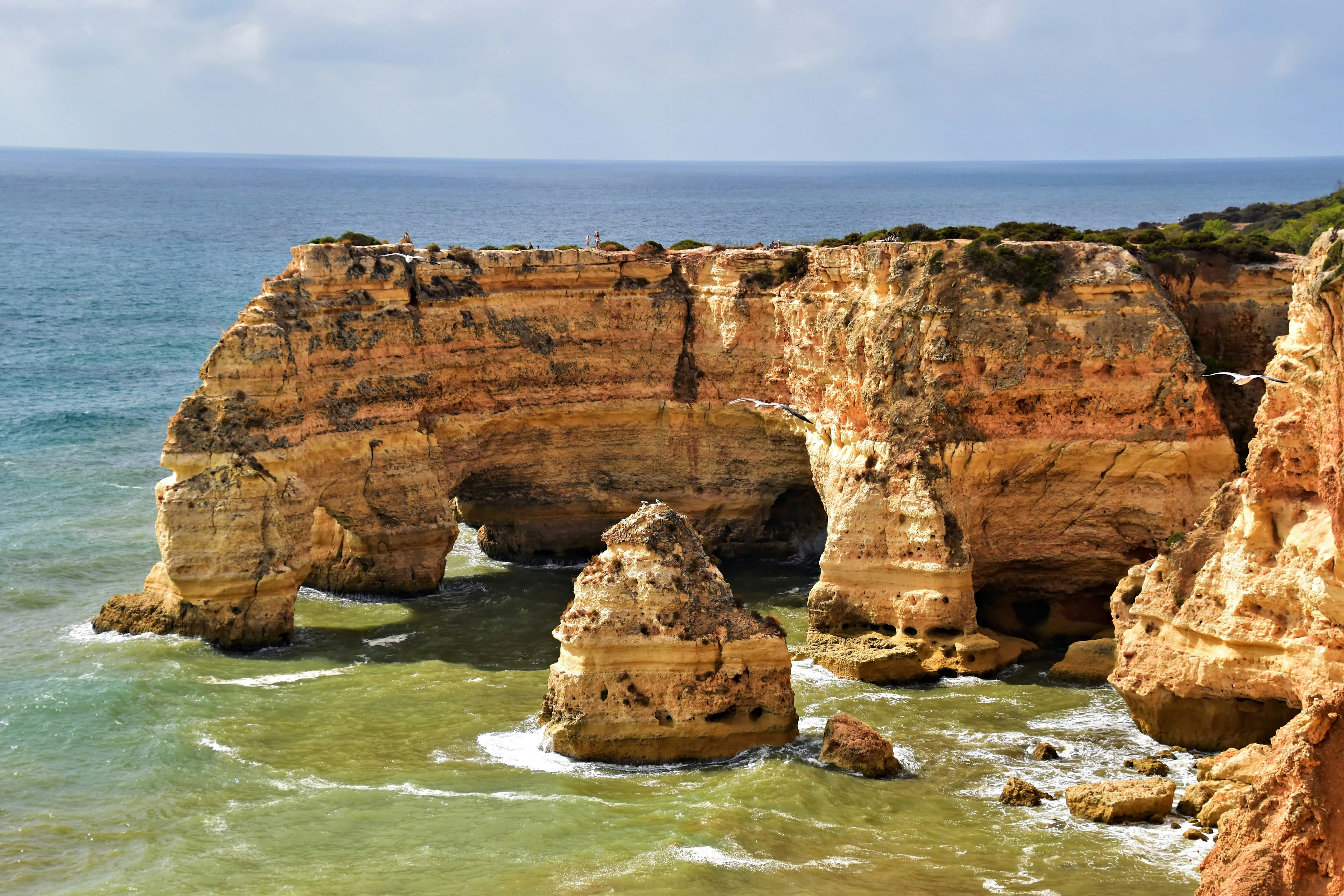 Jagged coastal cliffs with arches and ocean waves
