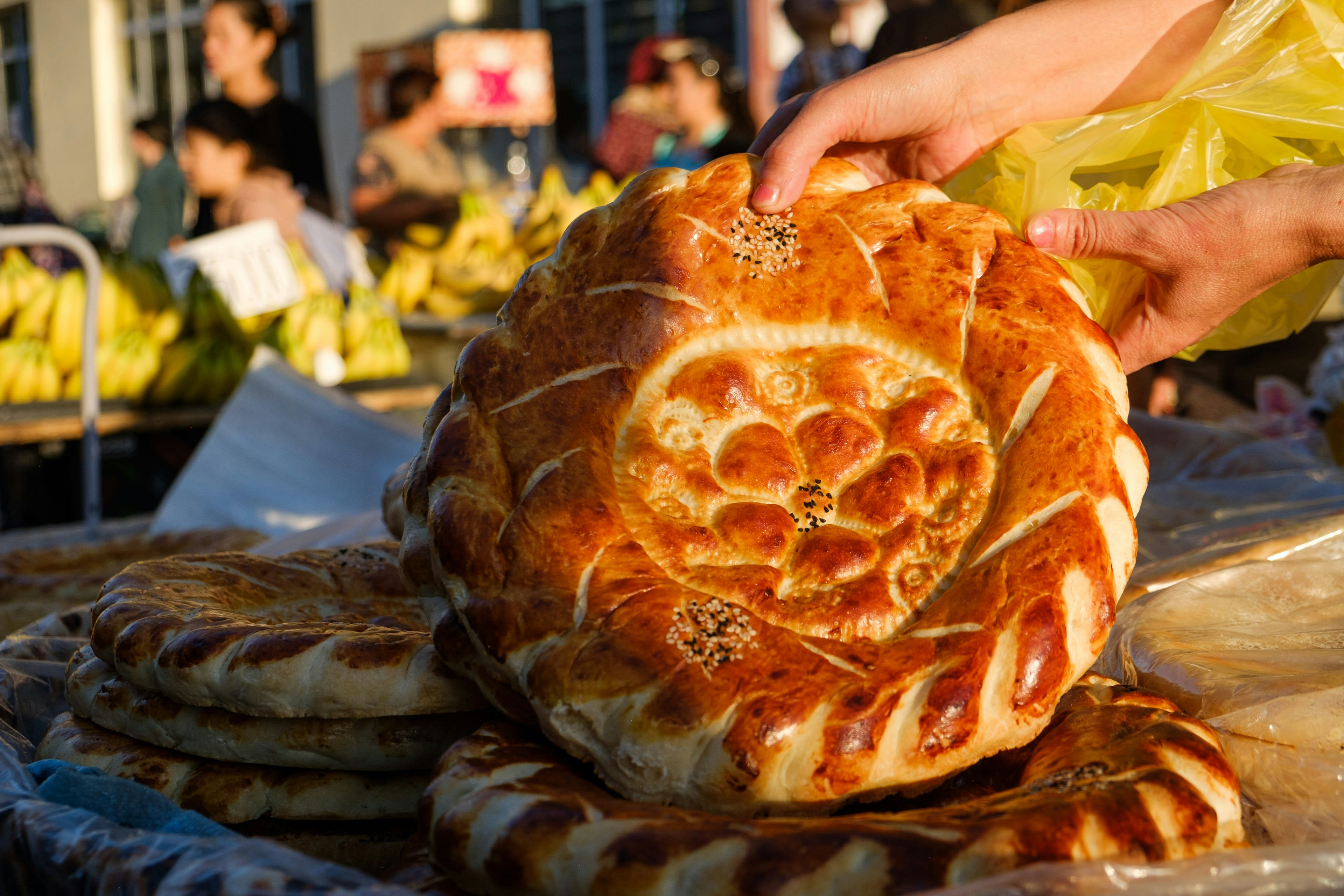 Hands holding a round stamped loaf of Samarkand bread
