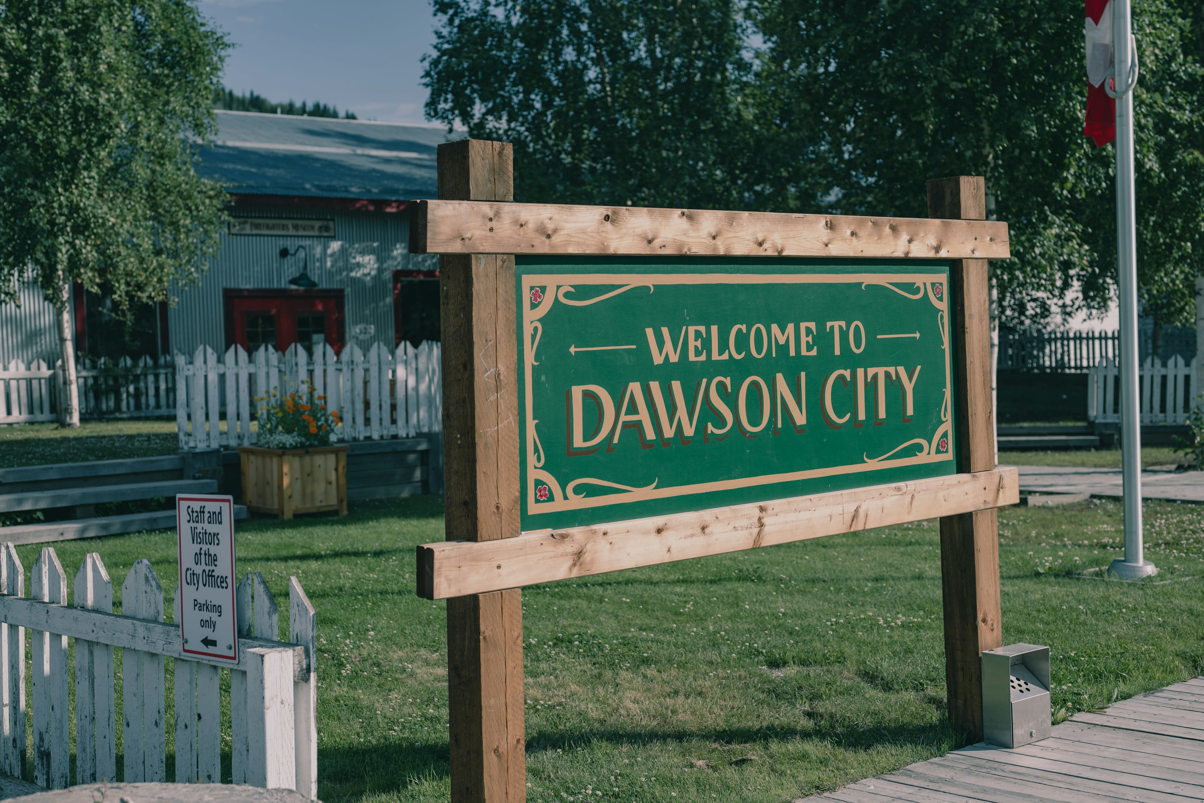 A hand-painted Welcome to Dawson City sign in low golden light