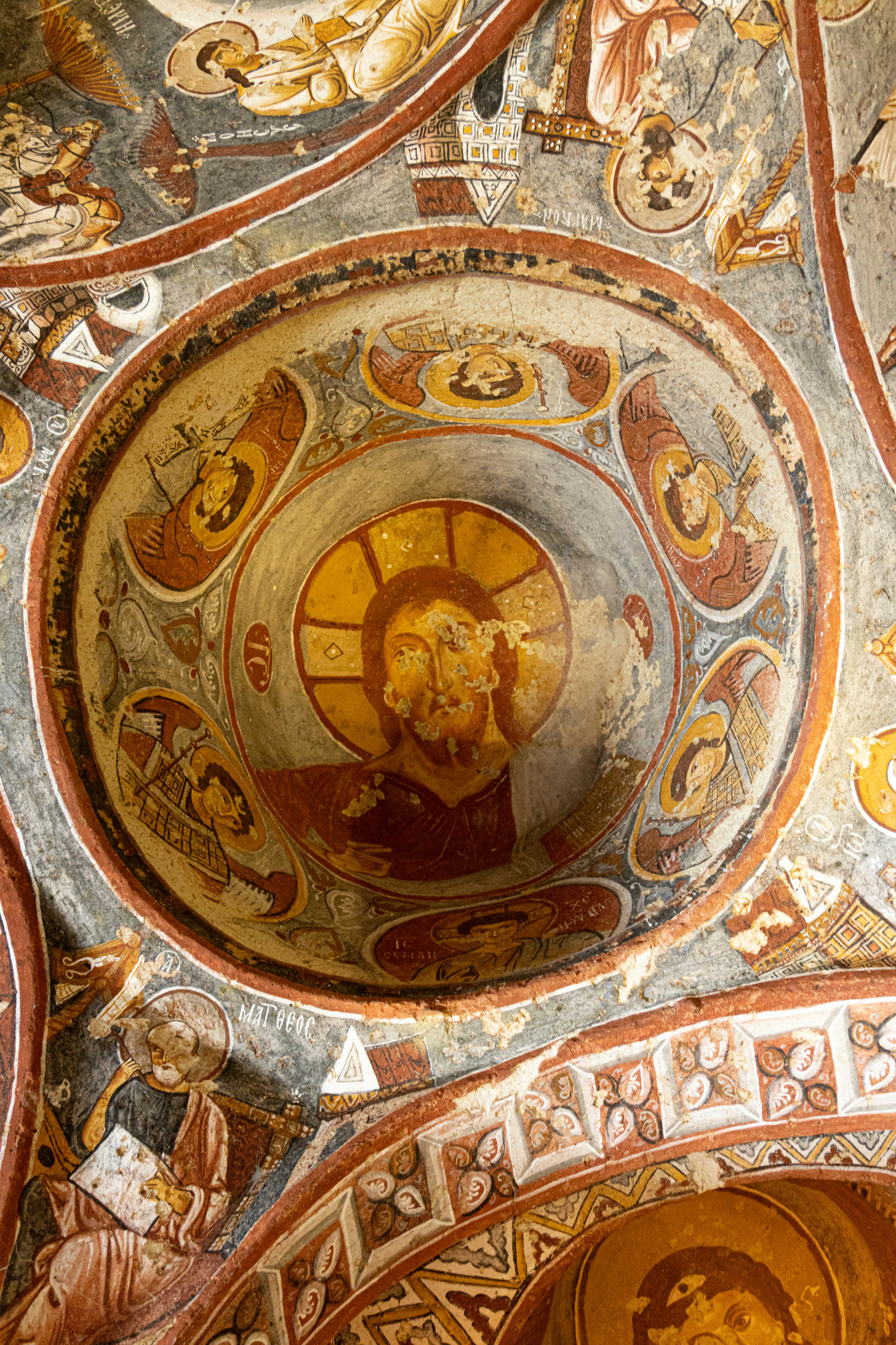 A Byzantine ceiling fresco of Christ surrounded by figures in a cave church