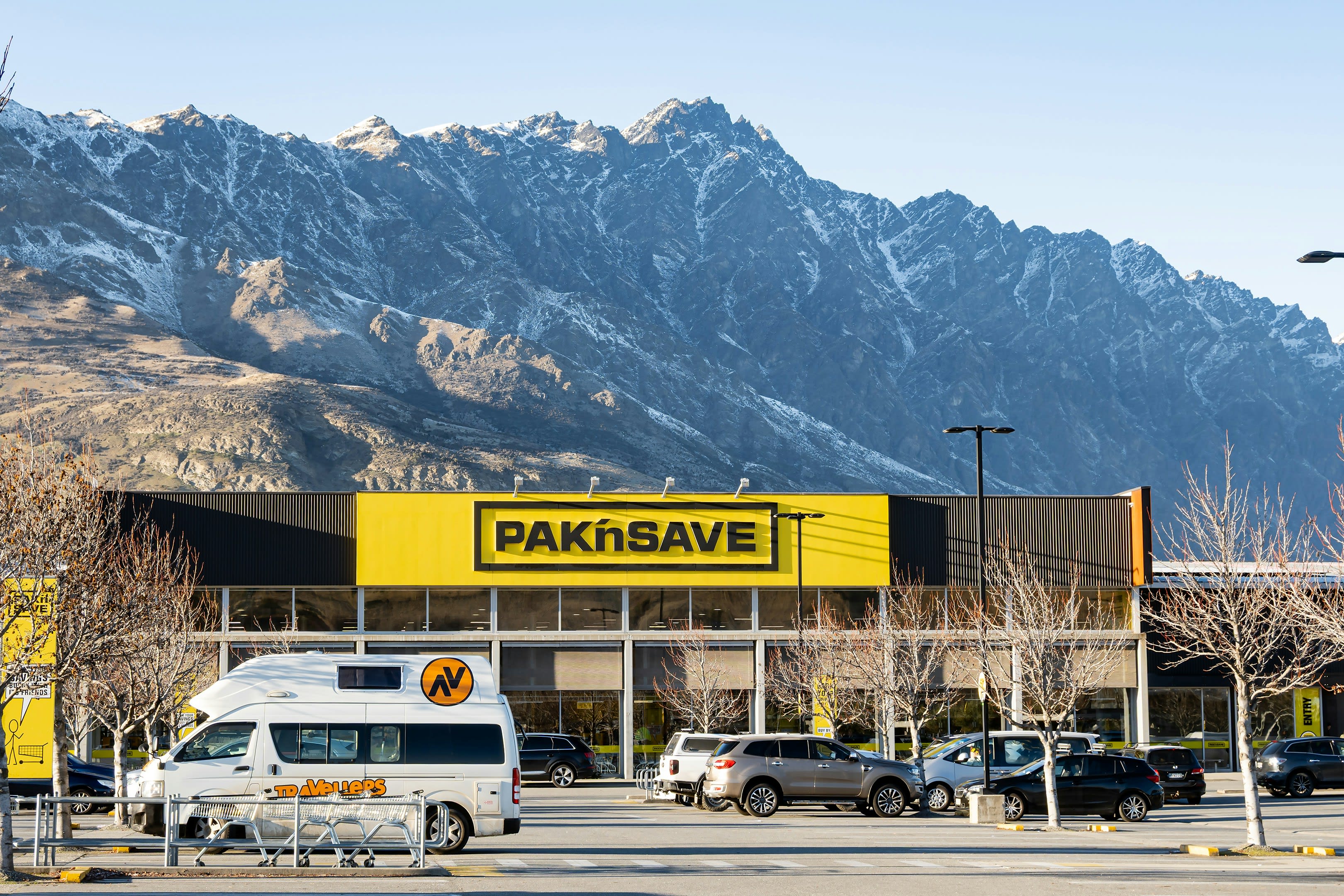 A supermarket car park with snowy mountain range rising behind it